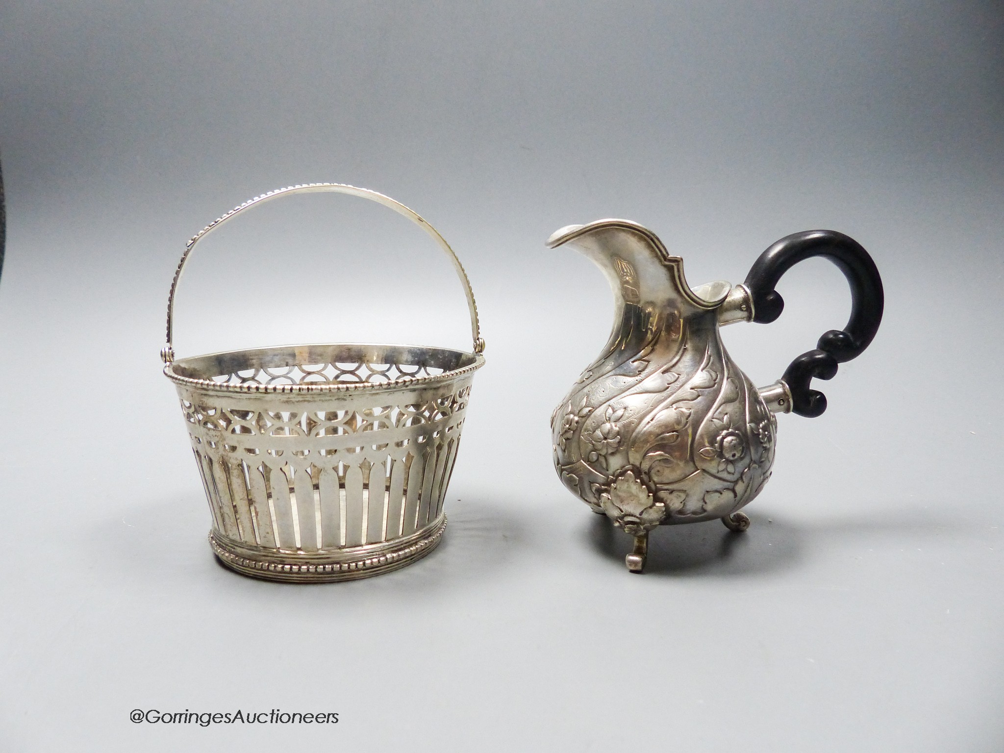 A 19th century Dutch white metal sugar basket (no liner), height 6cm and a Portuguese white metal cream jug, gross 7.5oz.